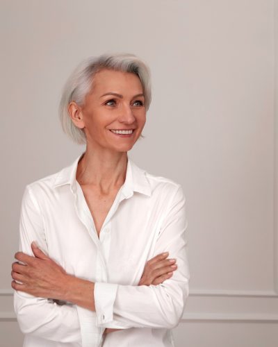 Close up portrait of beautiful older woman standing by wall